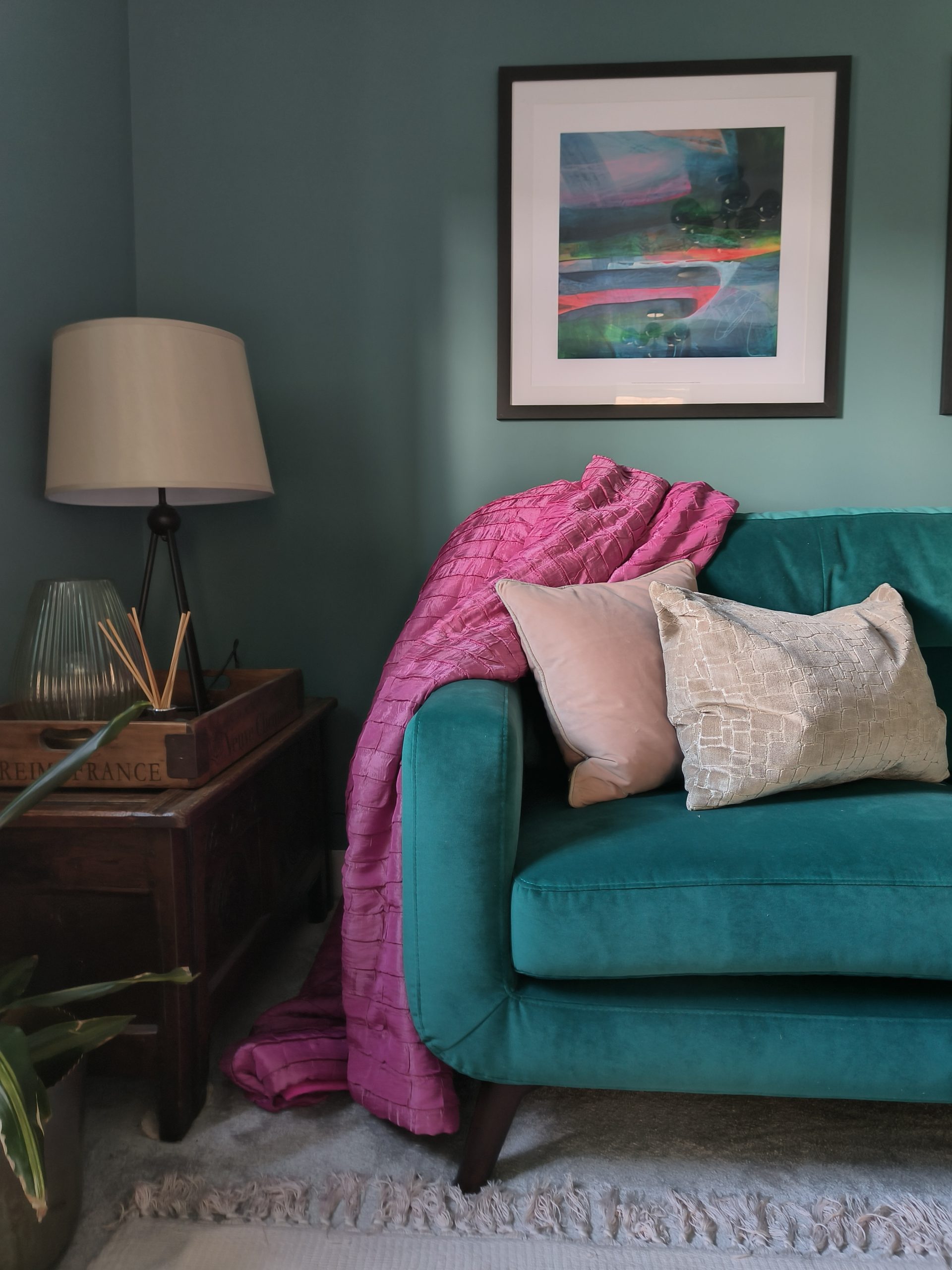 Pink throw over teal sofa
