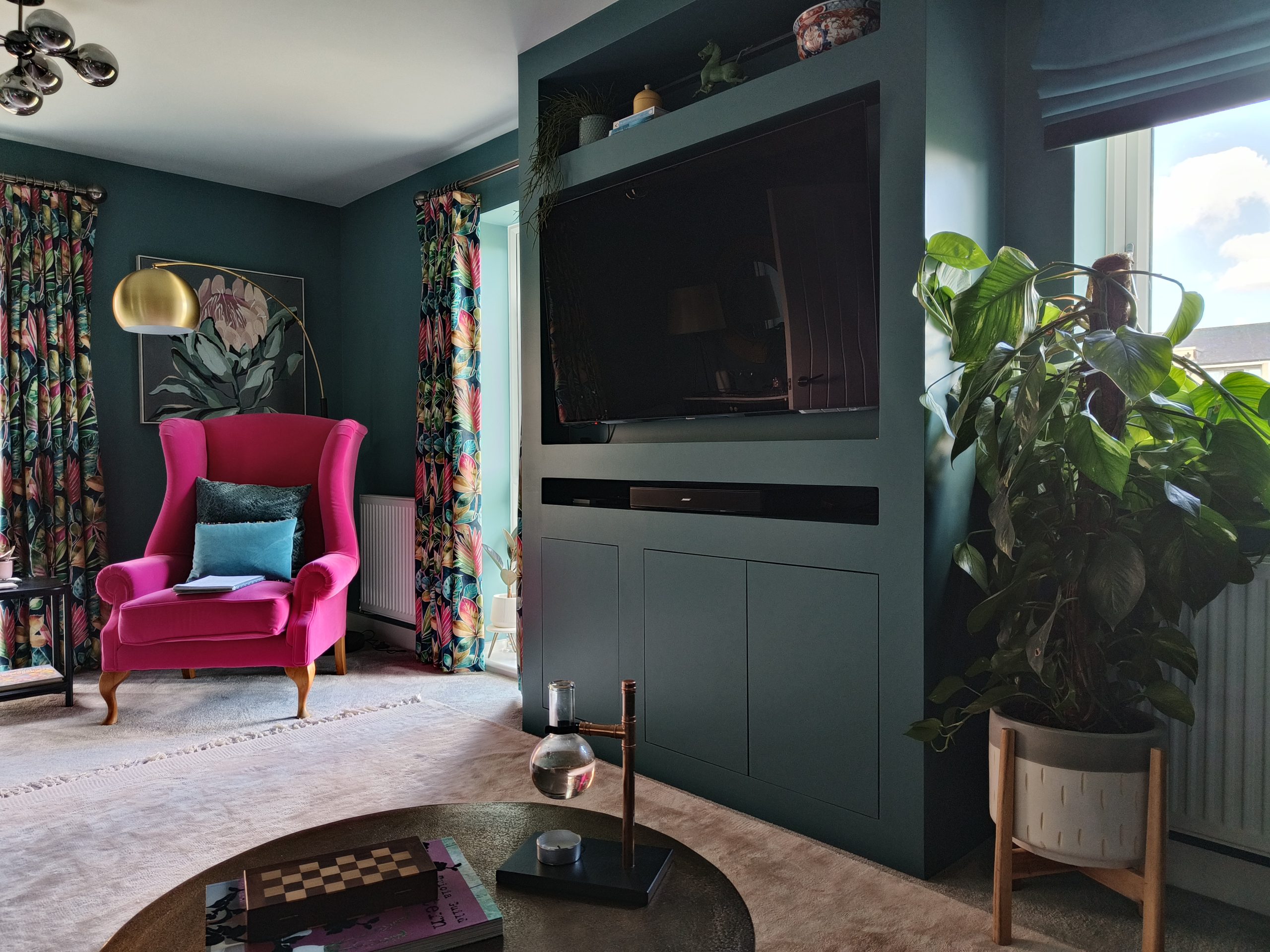 Teal media wall, pink chair