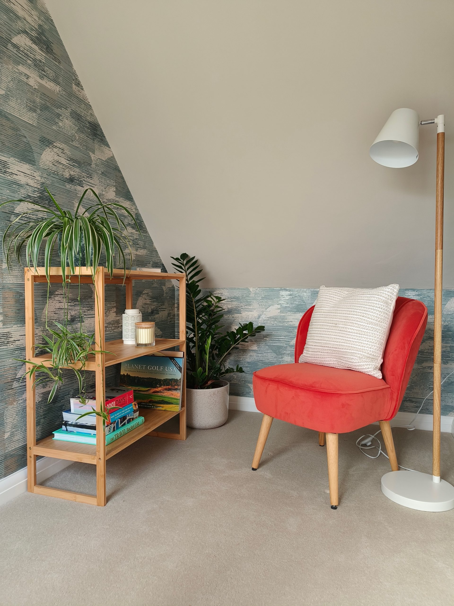 Cosy reading nook with textured wallpaper and orange chair