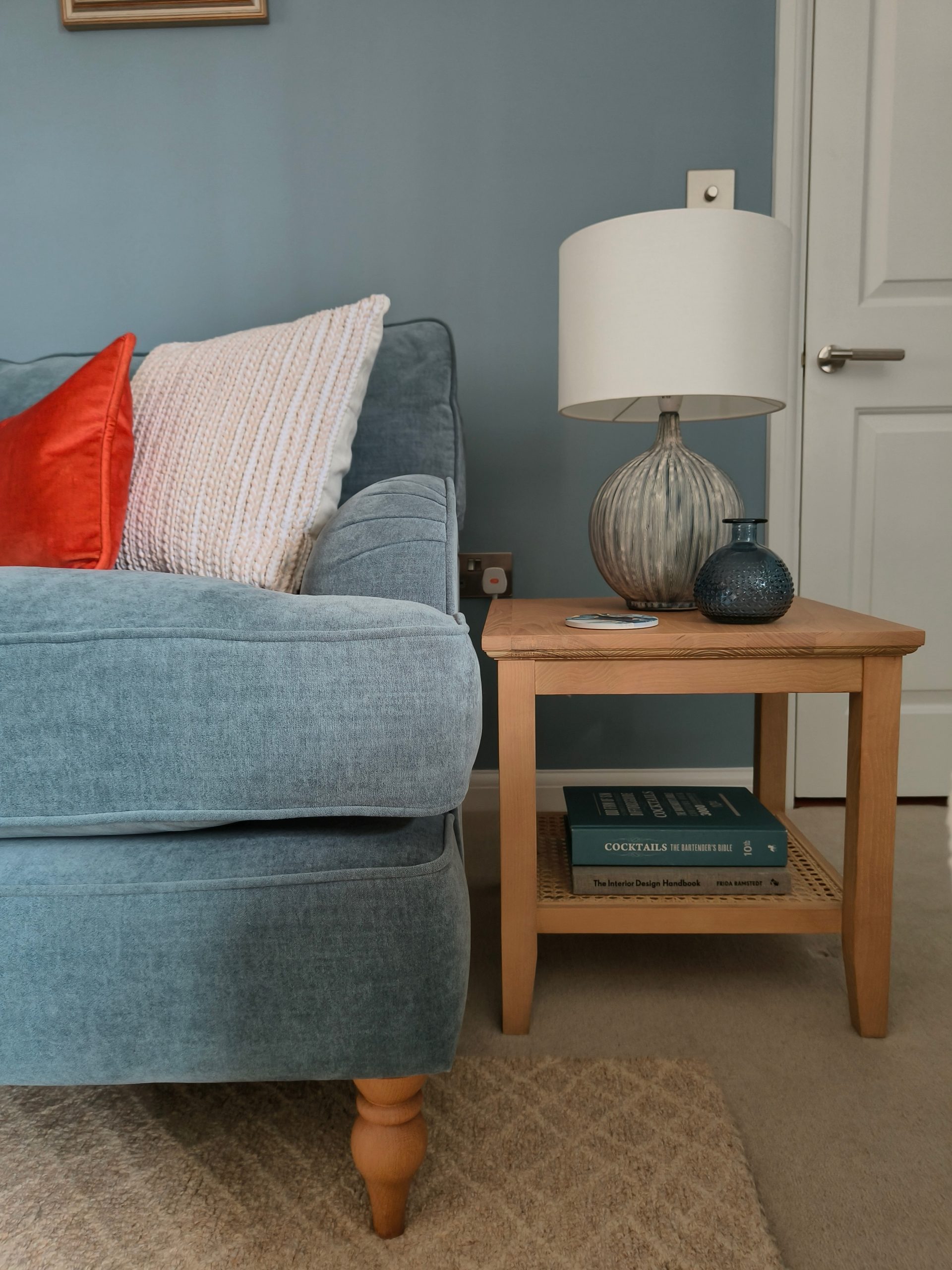 Blue sofa in blue living room with orange accents