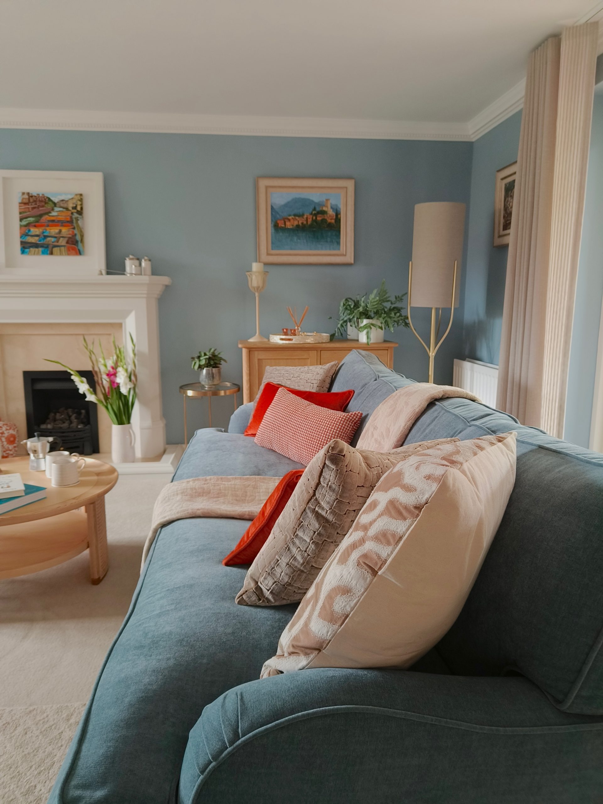 Calming blue living room with plenty of textures and warm pops of orange