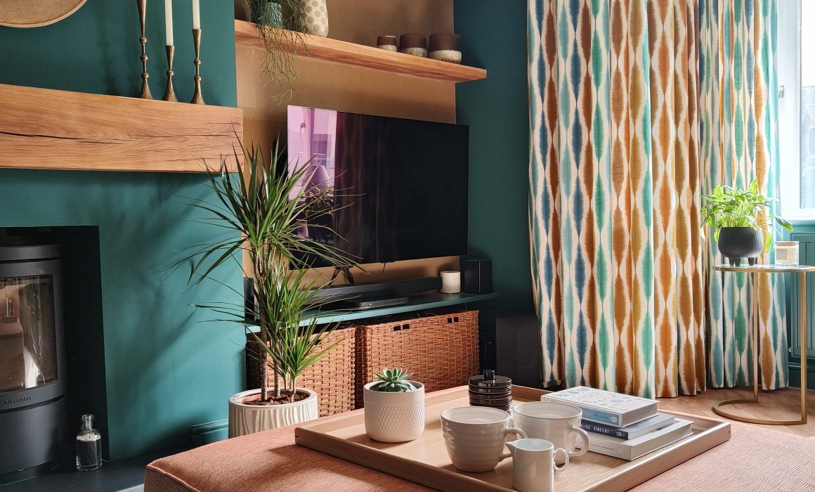 Teal living room with terracotta footstool and oak mantel