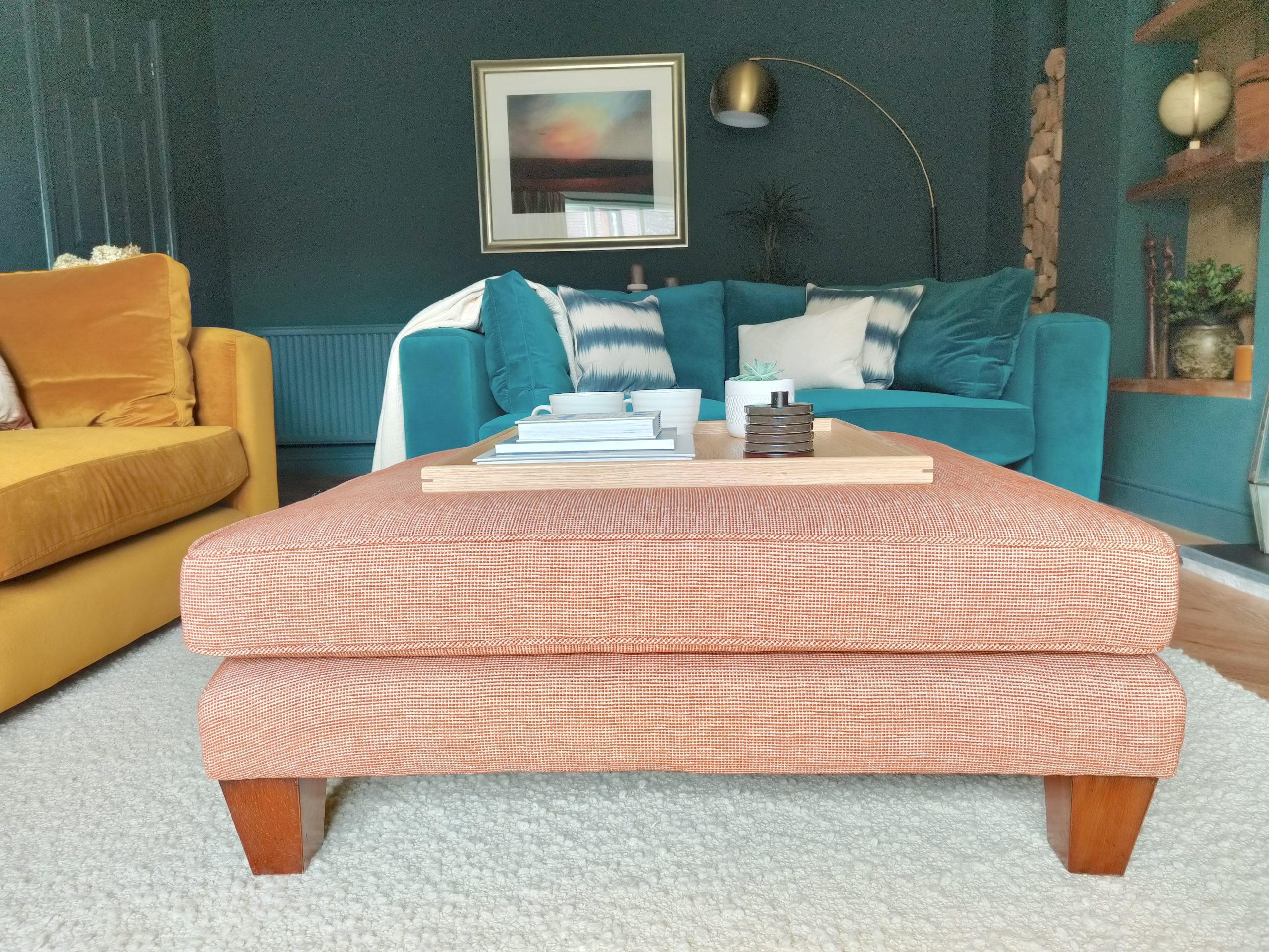 Terracotta footstool in teal living room